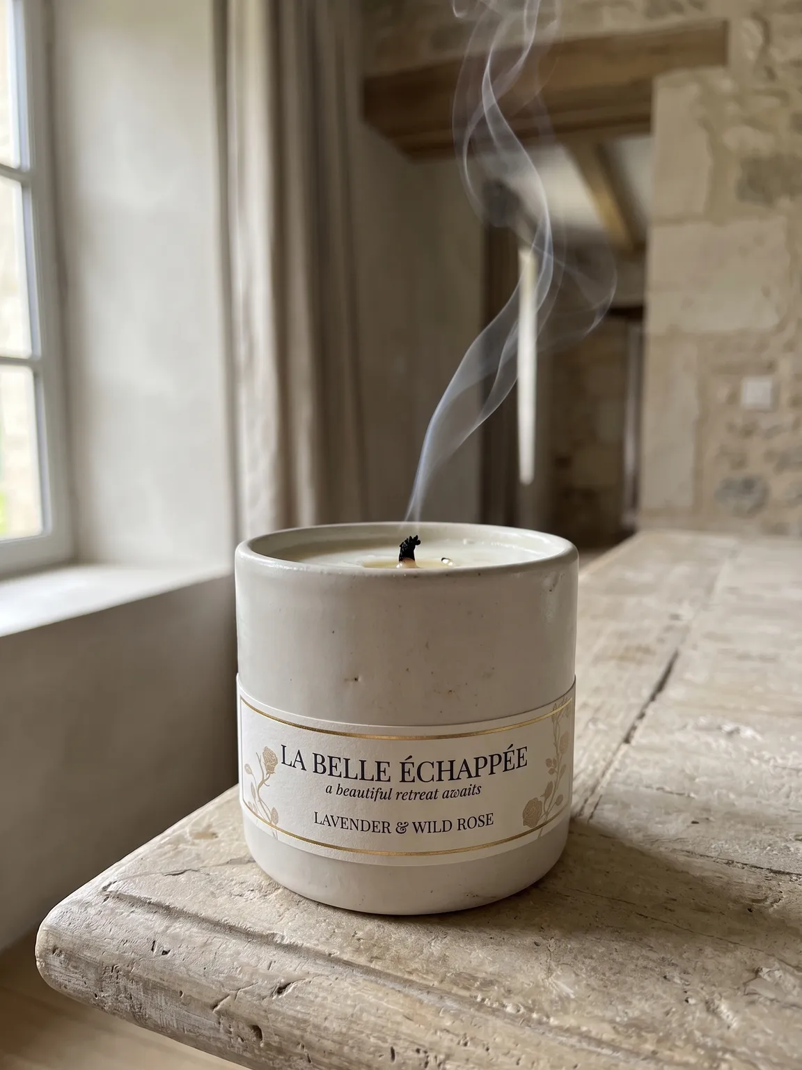 La Belle Échappée lavender and wild rose candle on a rustic windowsill
