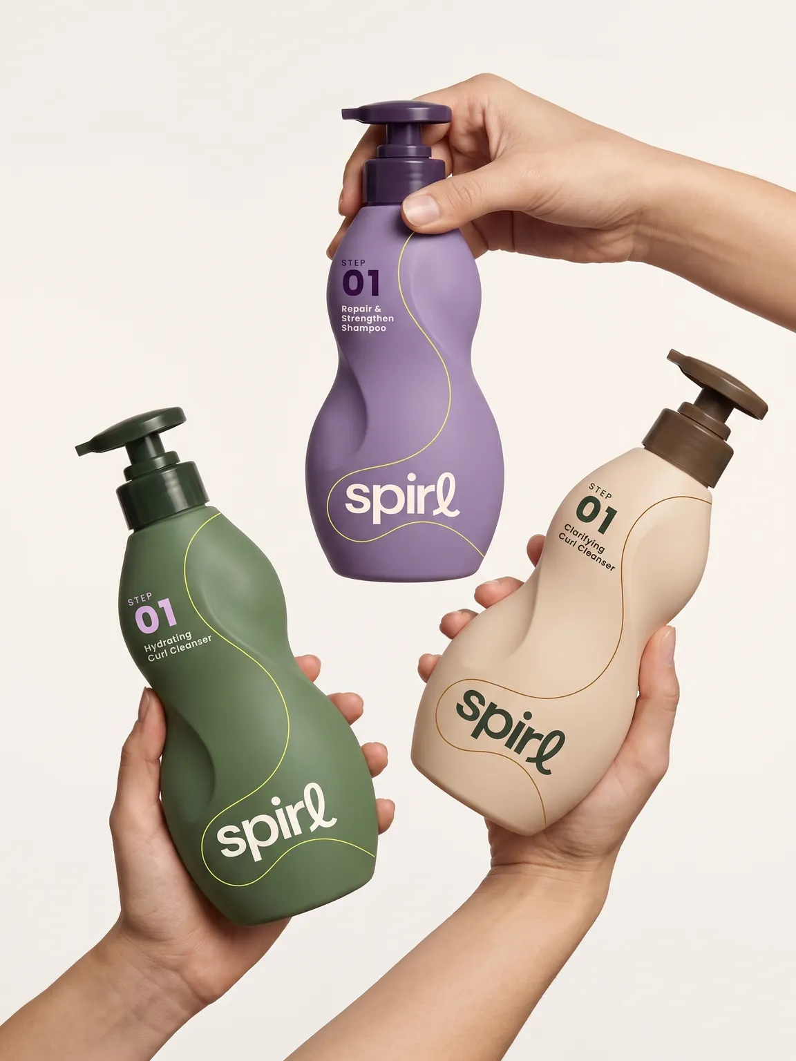 Three hands holding olive, purple and cream Spirl bottles against an off-white backdrop
