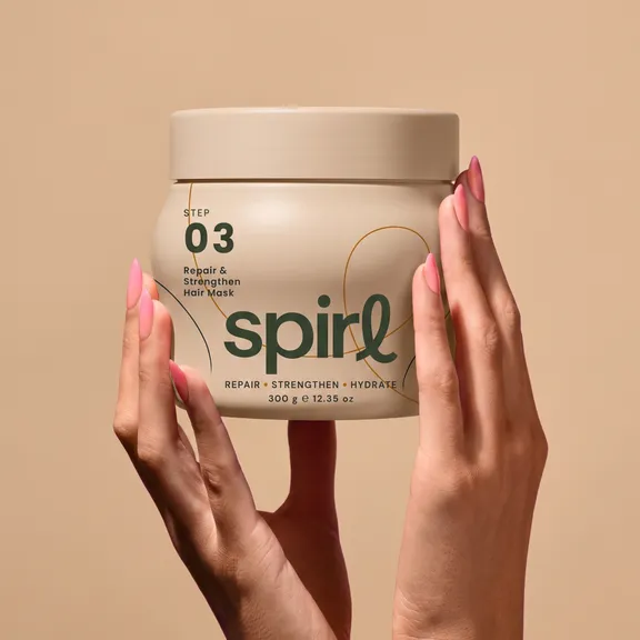 Hands presenting the Step 03 Repair & Strengthen Hair Mask jar
