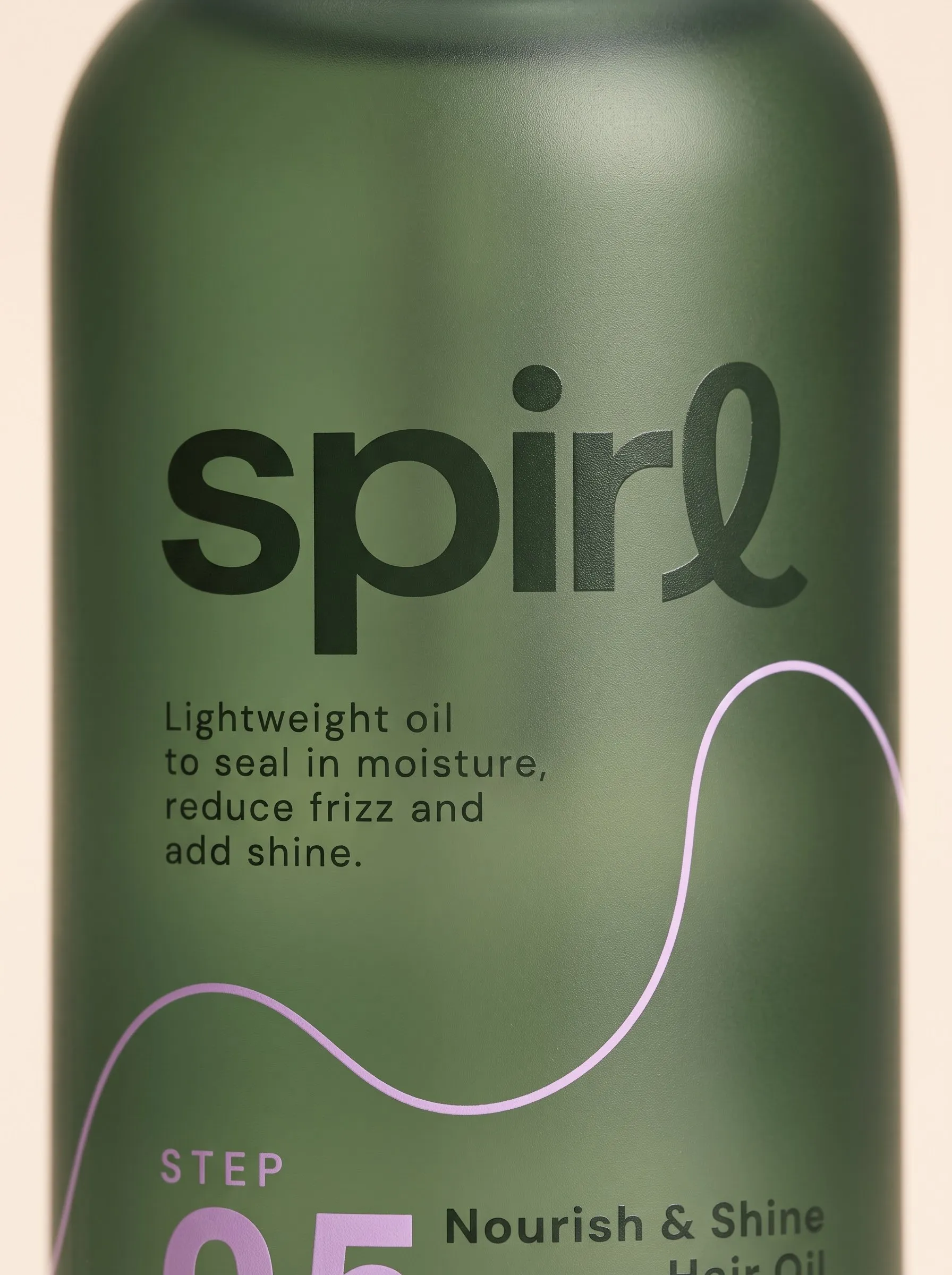 Label detail on the frosted green Nourish & Shine Hair Oil bottle